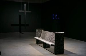 A bench with a cross on it in a dark room.