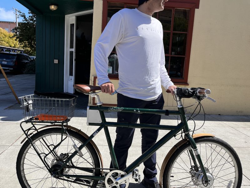 A man standing next to a bicycle.