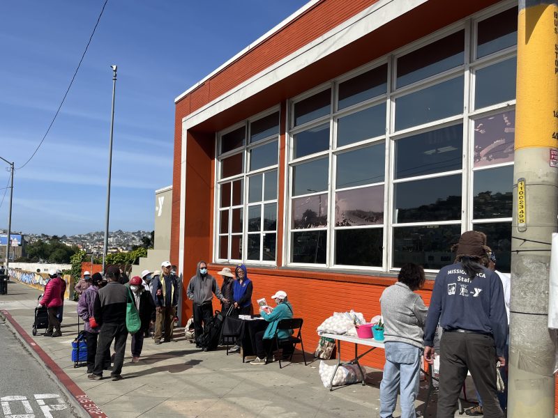 A line of people outside the Food Bank pantry at the Mission YMCA.