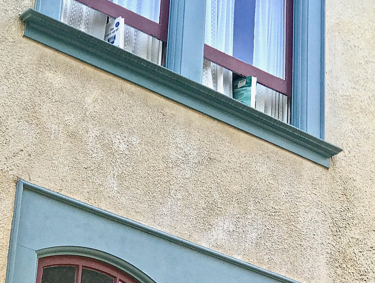 Two books propping open two windows.