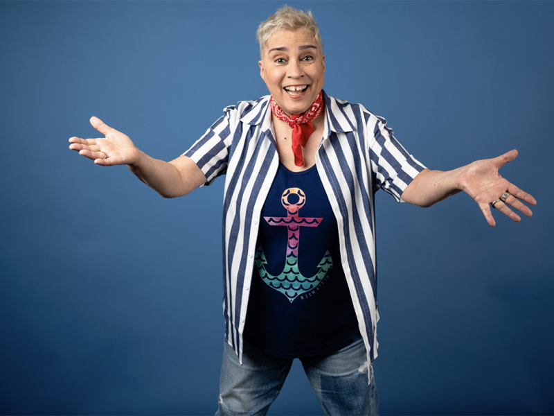 A woman wearing a striped shirt over an anchor t - shirt.