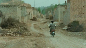 A man riding a bike down a dirt road.