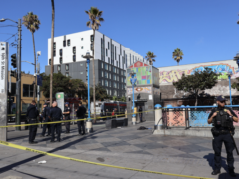A police officer is standing in front of a building.