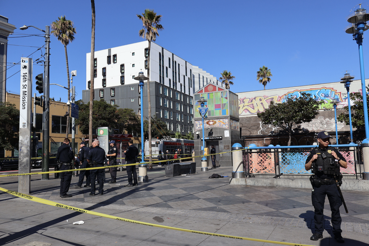 A police officer is standing in front of a building.