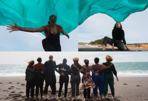A group of people standing on the beach with a green cloth.