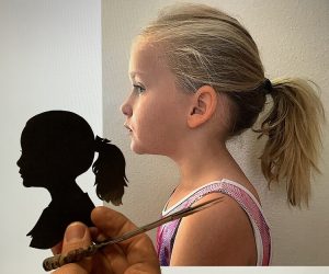 A little girl holding a pencil and a silhouette of a girl.