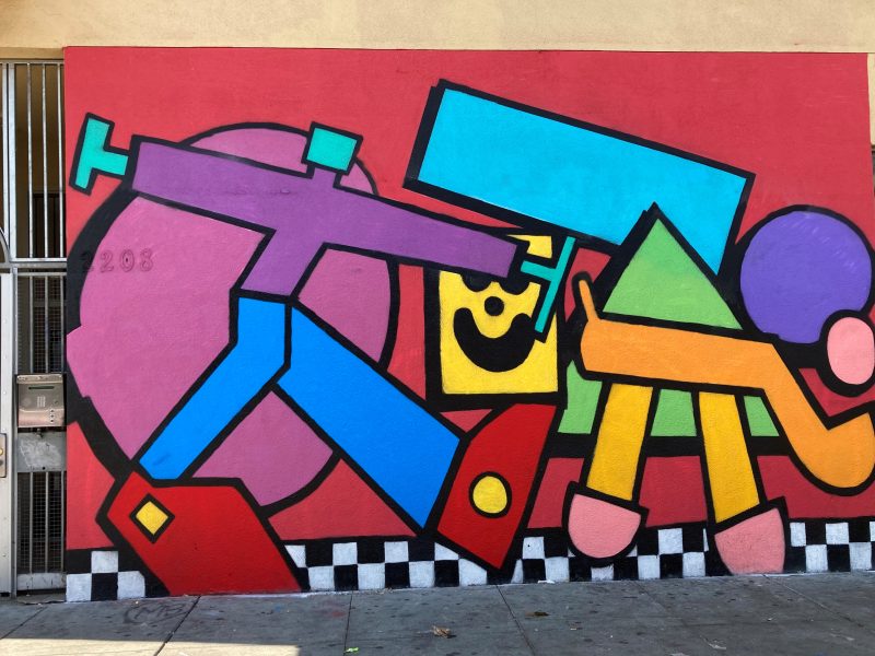Colorful wall art of a person walking a dog.