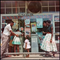 A group of people standing in front of a store.