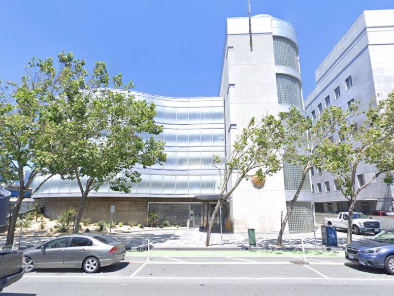 A building with parked cars in front of it in San Francisco.