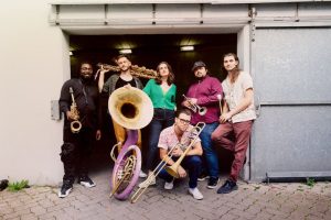A group of people posing in front of a garage.