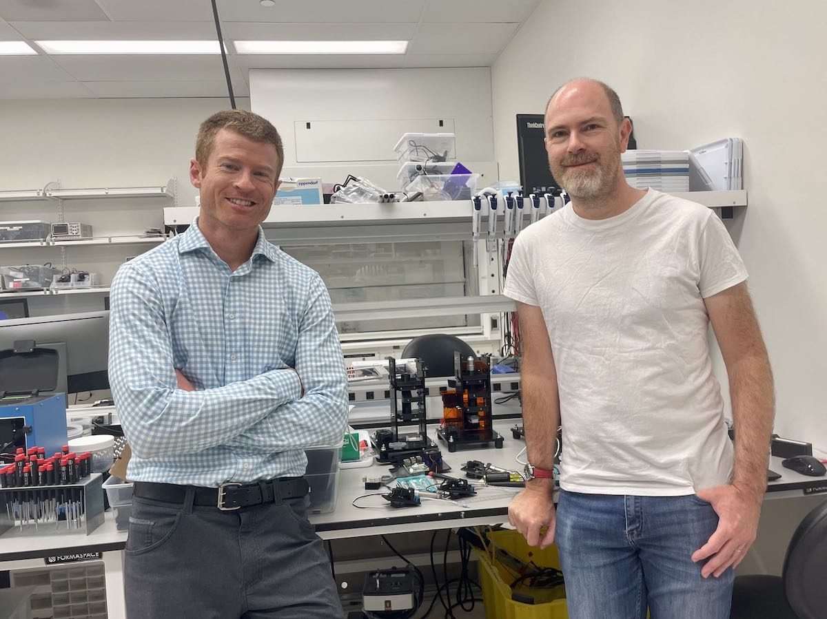 Two men standing next to each other in a lab.