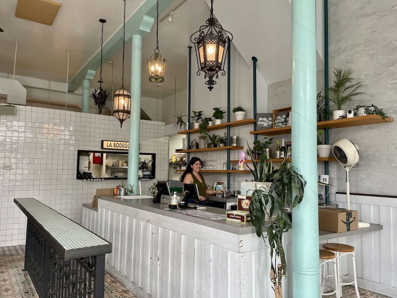 A woman is standing at the counter of media noche restaurant.