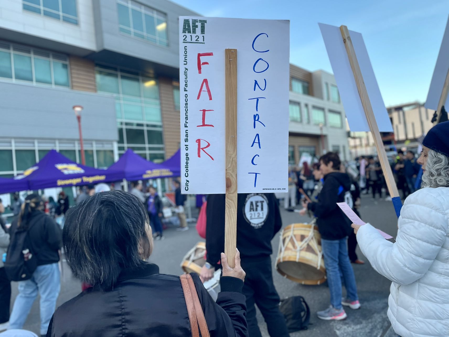A group of people holding signs that say fair contract at City College of San Francisco.