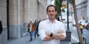 A man standing on a street with his arms crossed.