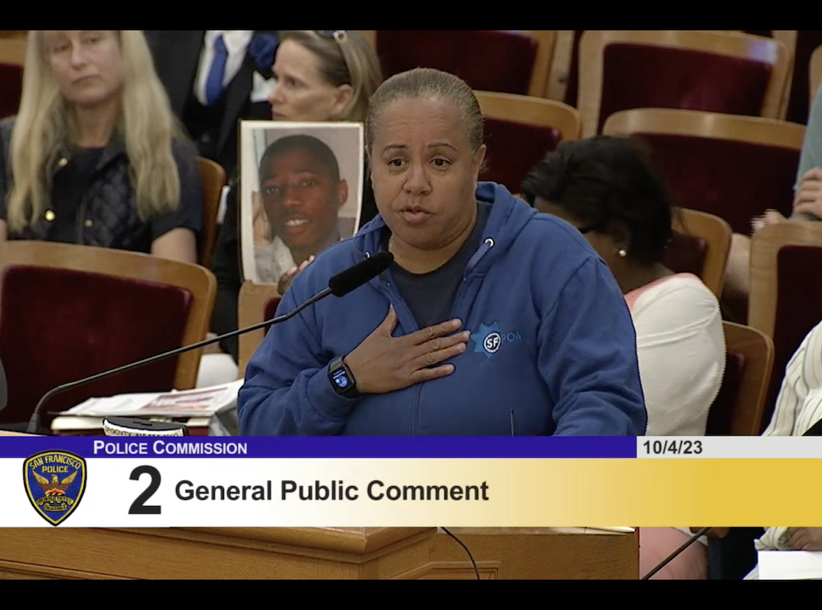 A woman is speaking in front of a group of people.