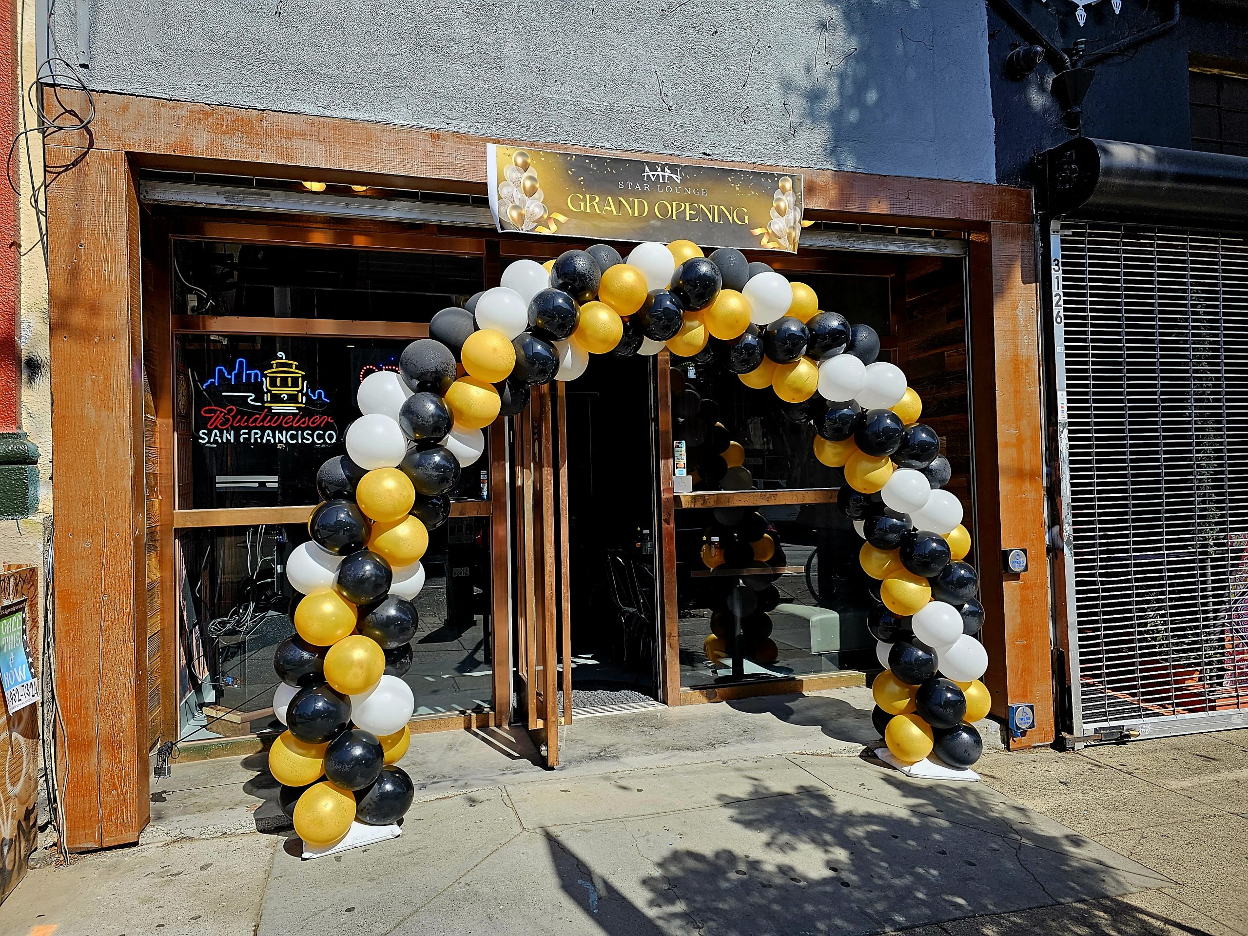 A black and gold balloon arch in front of the MN Star Lounge.
