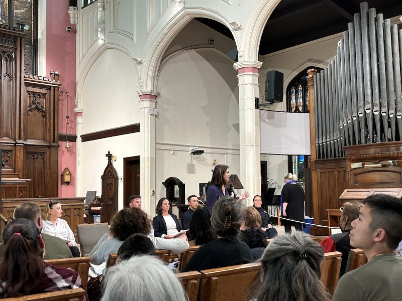 A group of people sitting in pews in a church.