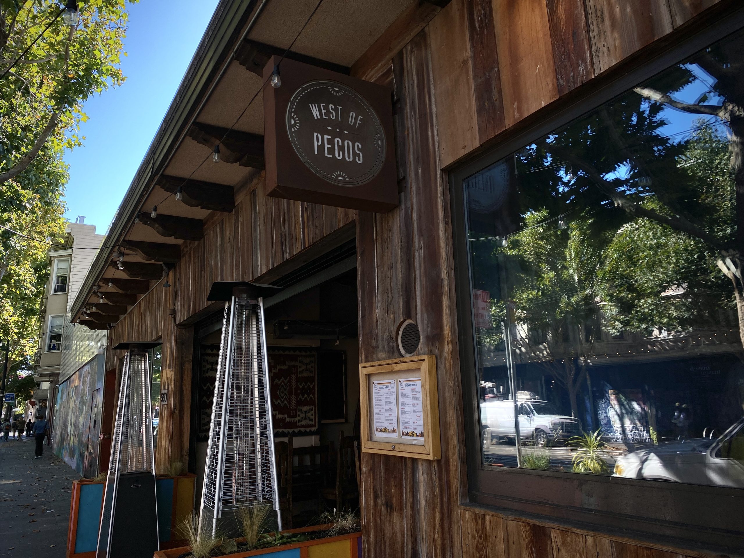 A restaurant with a wooden sign on the side of the building.