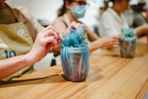 A group of women wearing masks at a table.