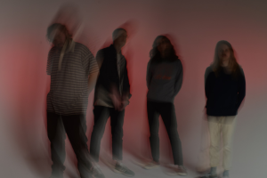 A blurry image of a group of people standing in front of a red light.