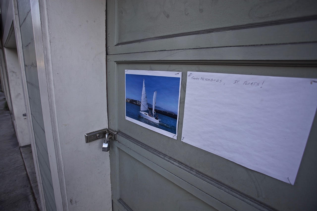 A photo of a sailboat on a grey door that is locked.