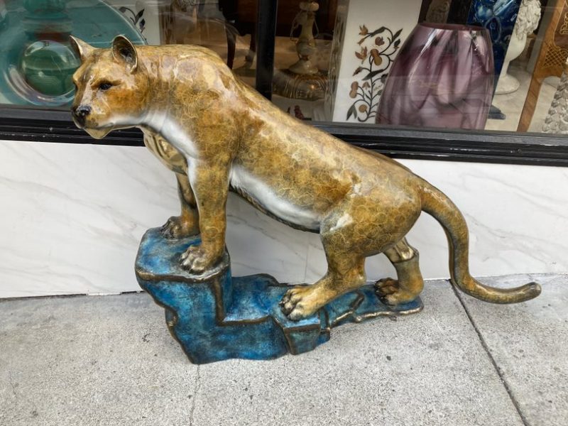 A statue of a lion standing on top of a rock.