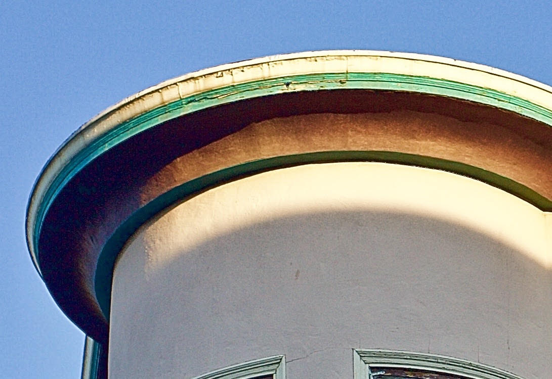 light and shadow on top of a beige building.