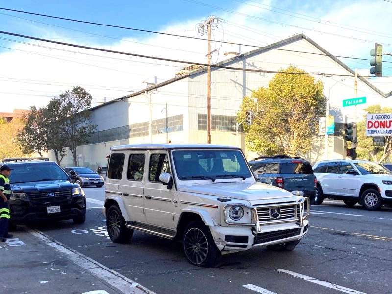 A white mercedes-benz car parked on a street.