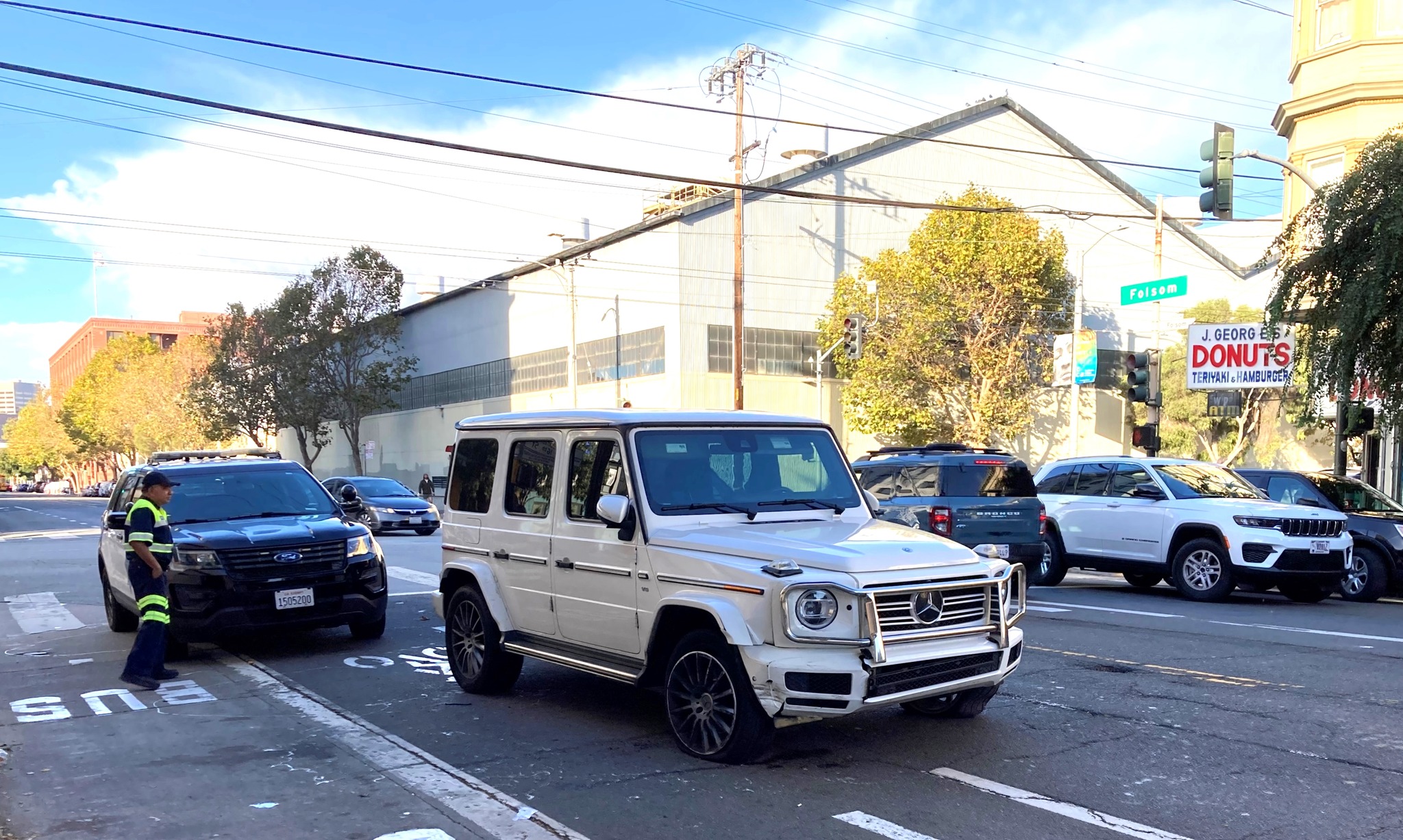 A white mercedes-benz car parked on a street.