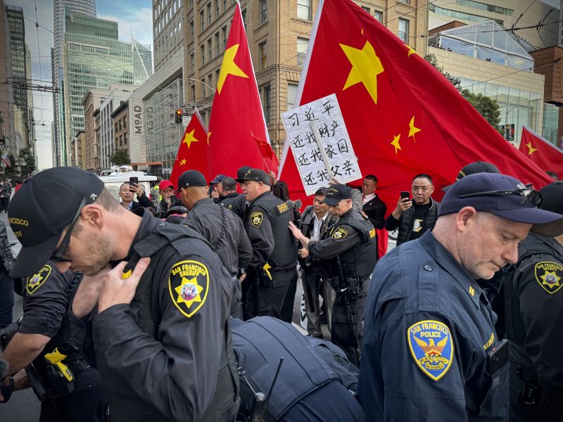 A group of police officers separating protesters from pro-China supporters