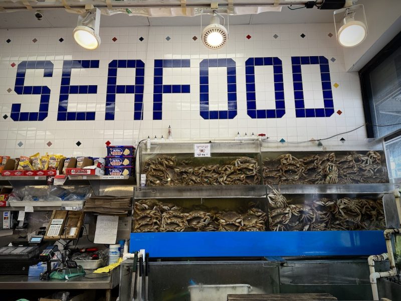 A fish market with a sign that says seafood, offering fresh Thanksgiving crabs.