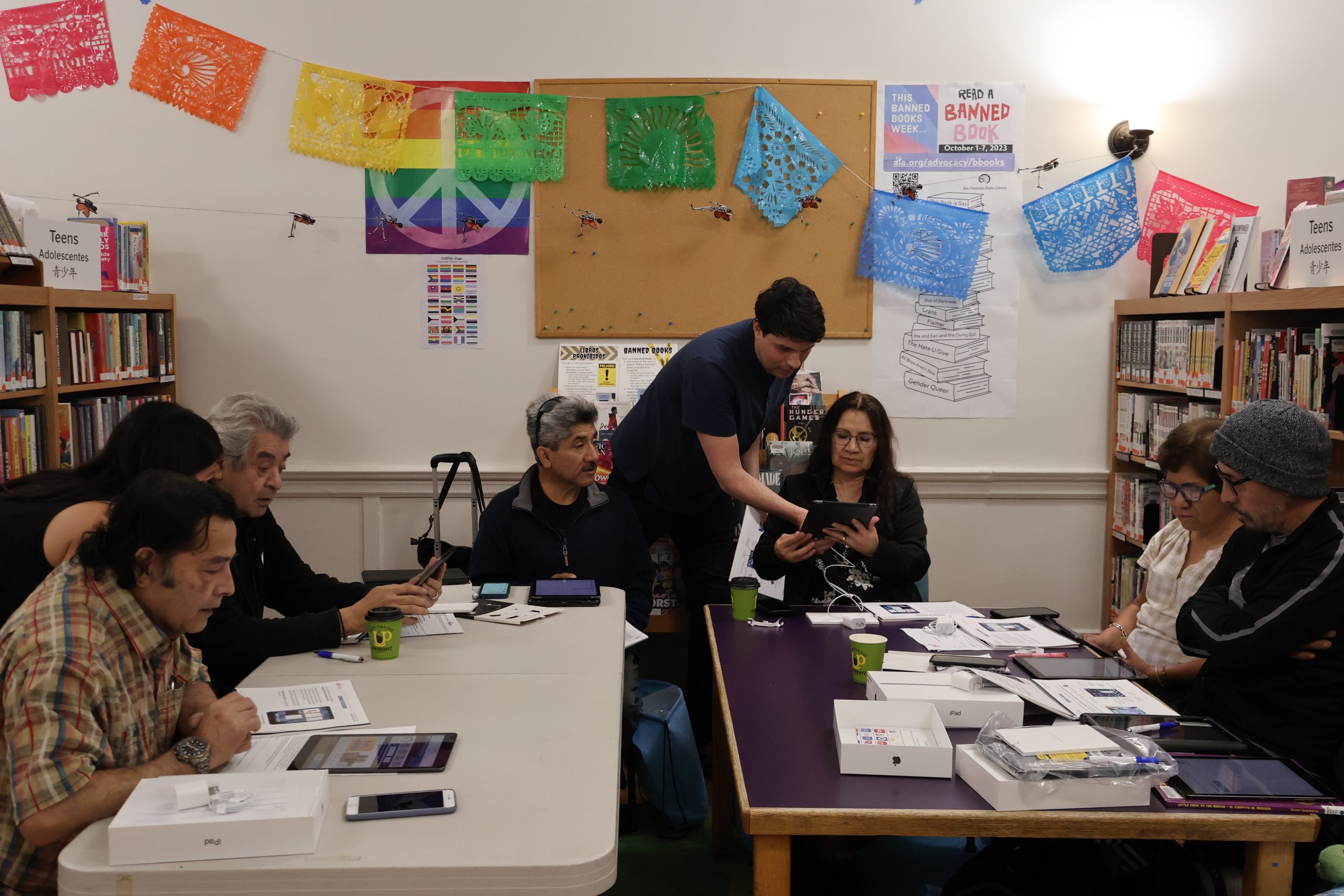 A group of people sitting around a table in a library.