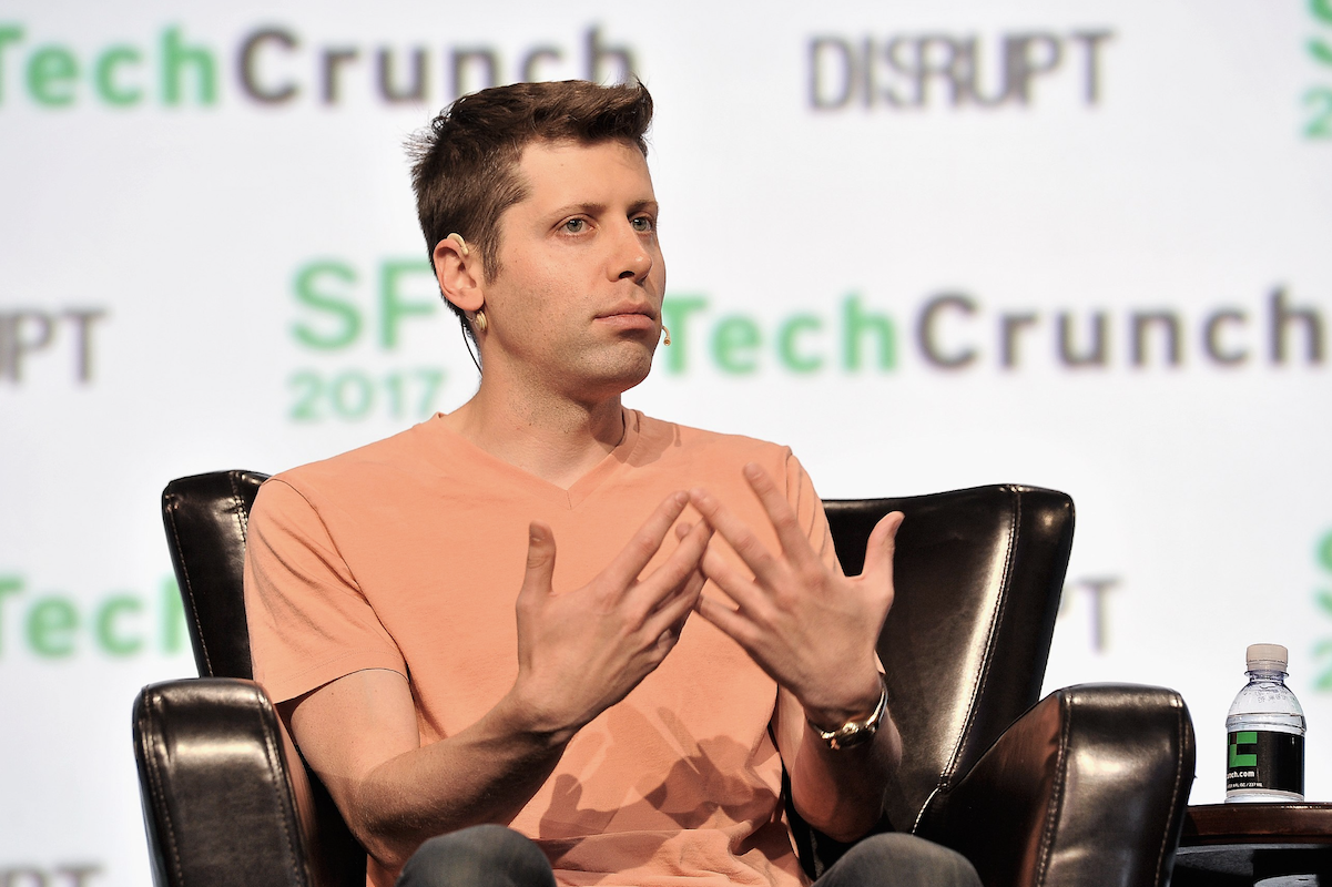 Sam Altman sitting in a chair at a TechCrunch event.