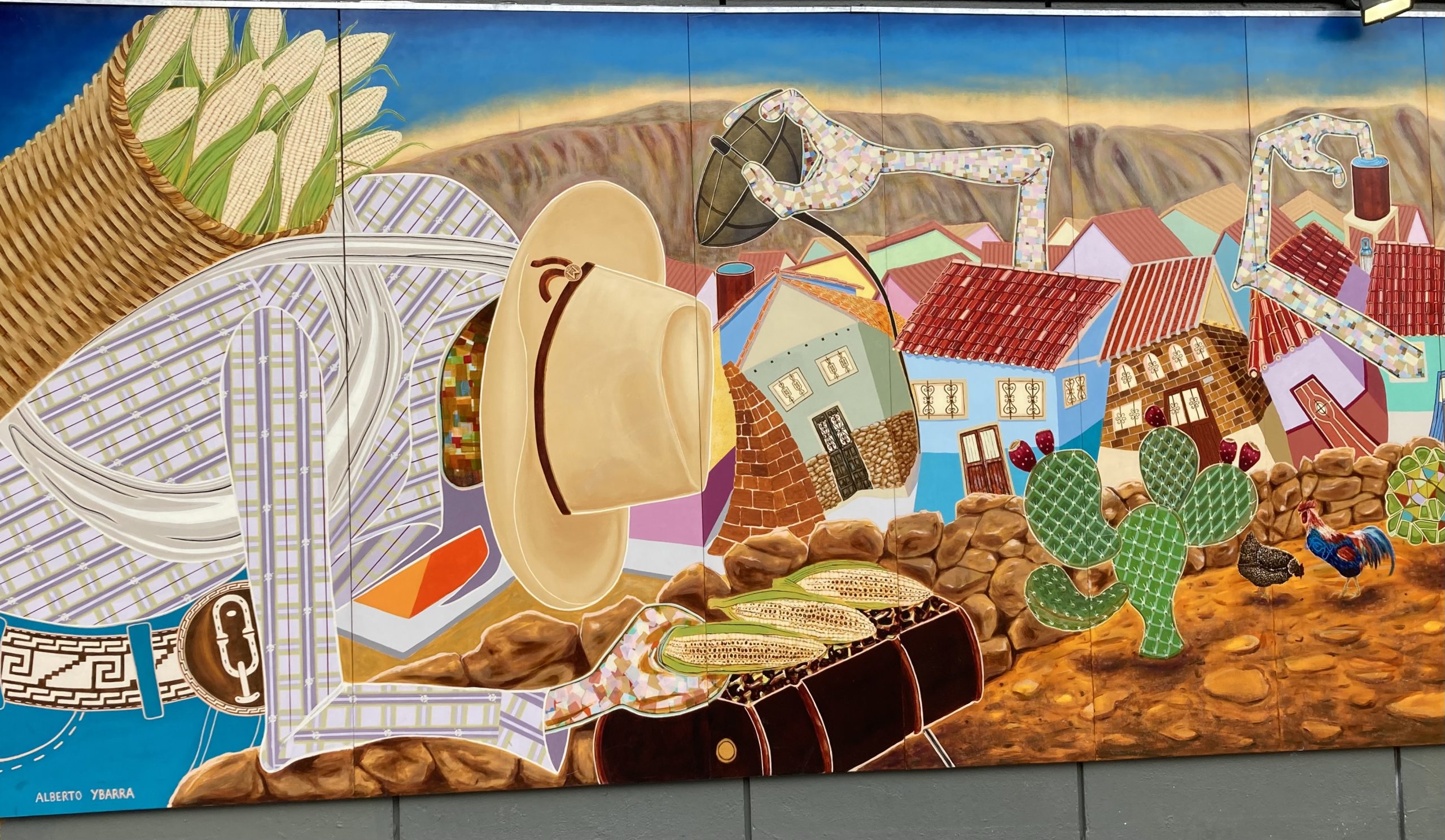 A mural on the side of a building with a man in a hat holding three cobs of corn in his hand and carrying a basket of corns on his back.