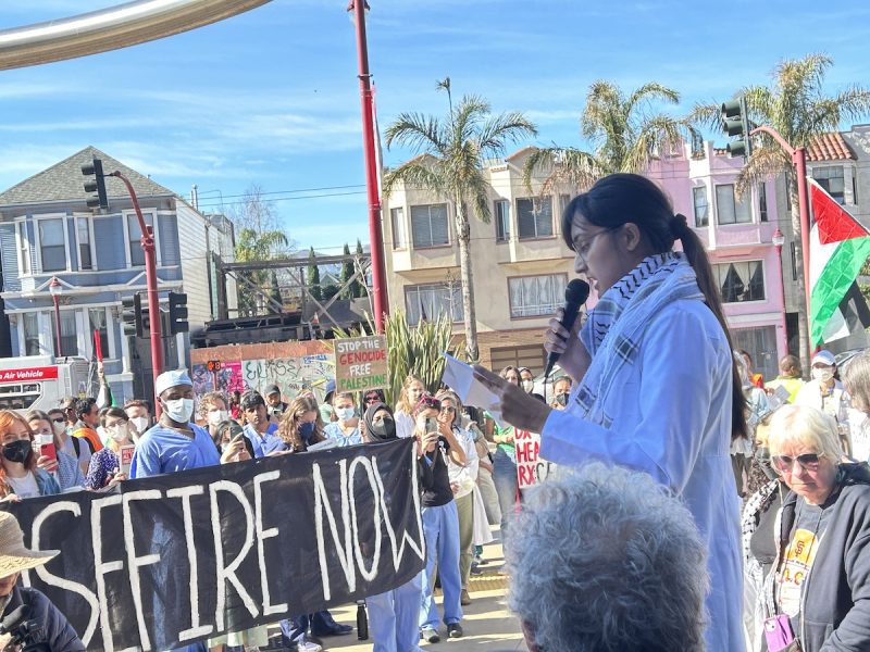 A woman holding a microphone in front of a crowd of people.