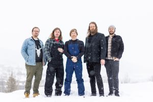 A group of men posing in the snow.
