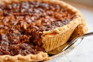 A pecan pie with a fork in the middle.