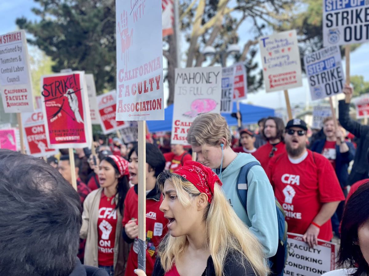 A group of people holding signs at a protest at SF State University
