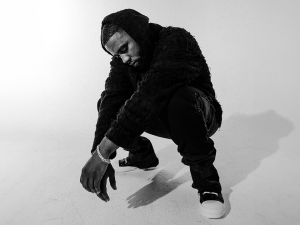 A black and white photo of a man in a hoodie.