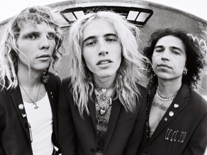 A black and white photo of three men with long hair.