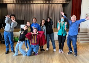 A group of people posing for a picture in a classroom.