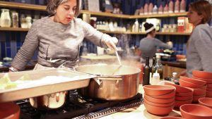 A woman is preparing food in a kitchen.
