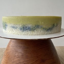 A cake sitting on top of a wooden stand.