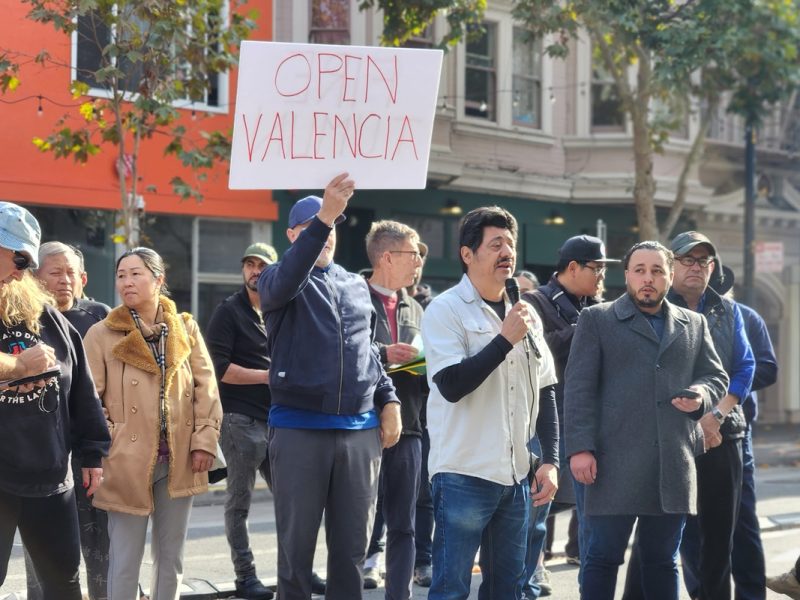A group of people holding signs on a street.