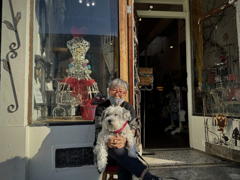 Yaeko Yamashita sitting in front of a store with her dog, Chabo