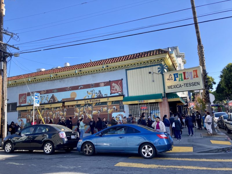 A group of people queue in front of La Palma for masa