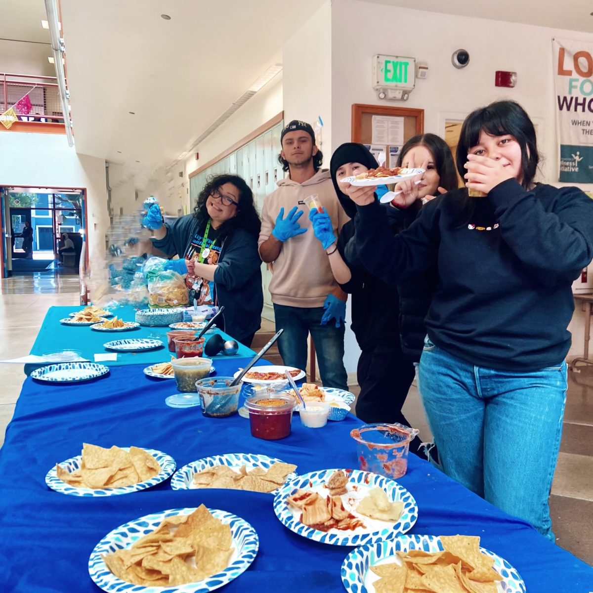 A group of people standing around a table with plates of food.