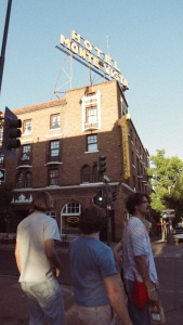 A group of people walking down the street in front of a building.