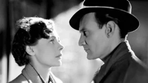 A black and white photo of a man and woman looking at each other.