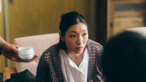 A woman is sitting on a couch with a cup of tea.